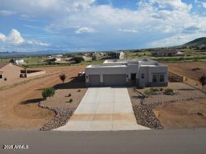 pueblo-style house featuring a garage and concrete driveway