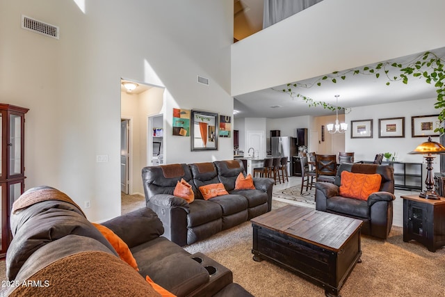 carpeted living room featuring an inviting chandelier and a high ceiling