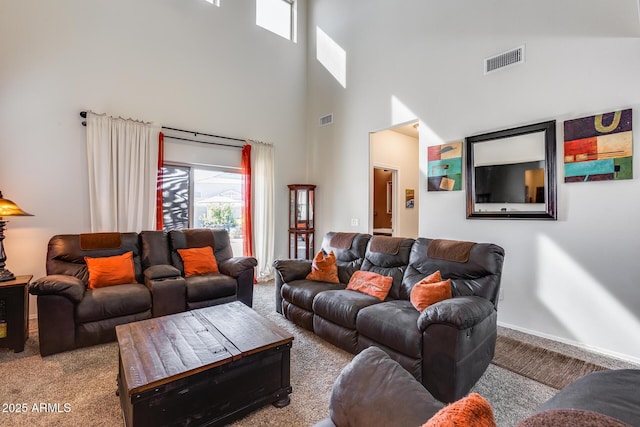 carpeted living room featuring a high ceiling