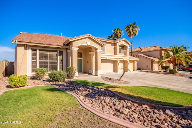 mediterranean / spanish-style home featuring a front lawn and a garage