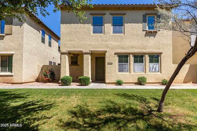 view of front of house with a front yard, stucco siding, and fence