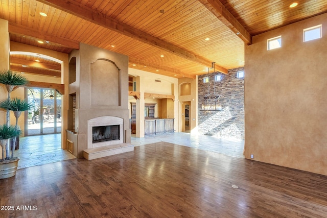 9980 E Charter Oak Rd, Scottsdale, AZ 85260 - unfurnished living room featuring a towering ceiling, beam ceiling, hardwood / wood-style floors, and wooden ceiling