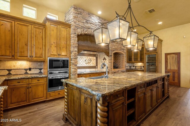 9980 E Charter Oak Rd, Scottsdale, AZ 85260 - kitchen featuring sink, decorative light fixtures, black microwave, a large island with sink, and oven