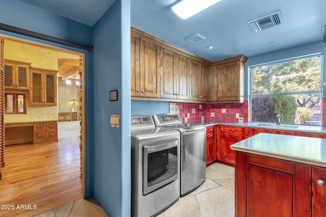9980 E Charter Oak Rd, Scottsdale, AZ 85260 - laundry room with cabinets, light hardwood / wood-style floors, sink, and washer and dryer
