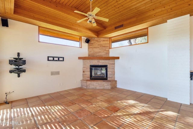 9980 E Charter Oak Rd, Scottsdale, AZ 85260 - unfurnished living room with tile patterned flooring, wood ceiling, a stone fireplace, and ceiling fan