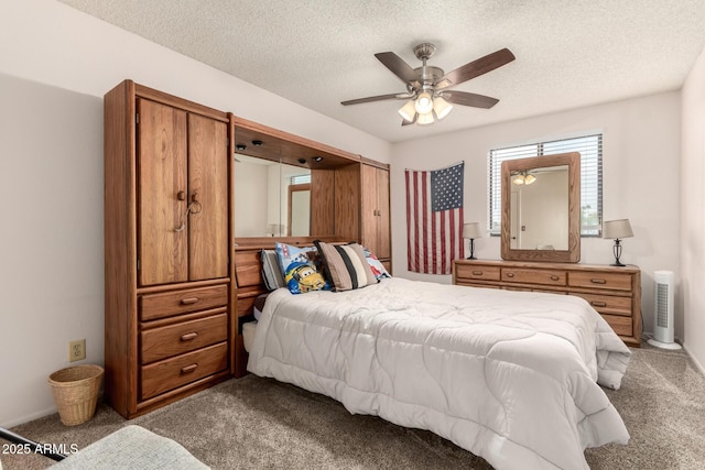 bedroom featuring ceiling fan, carpet, and a textured ceiling