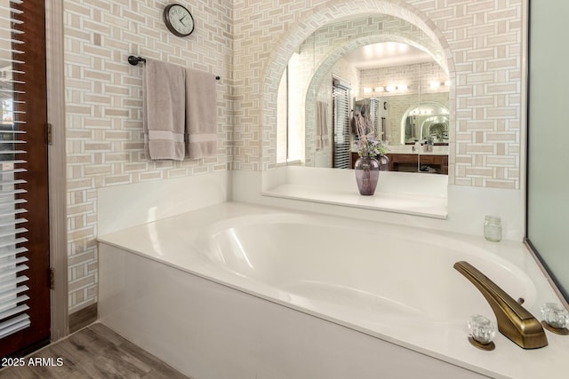 bathroom featuring a bath and wood finished floors