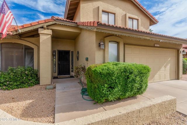 exterior space with a tiled roof, driveway, a garage, and stucco siding
