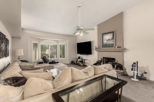 carpeted living room featuring a fireplace and a ceiling fan
