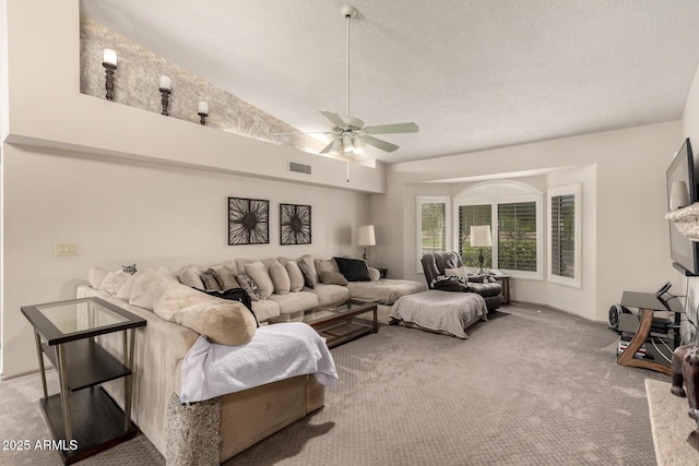 carpeted living area with visible vents, a textured ceiling, and ceiling fan