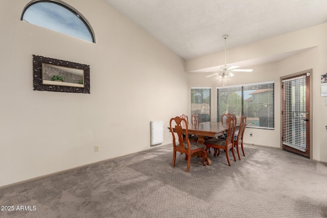 dining area with ceiling fan, lofted ceiling, and carpet