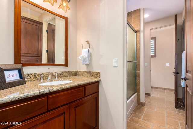 bathroom with vanity and combined bath / shower with glass door