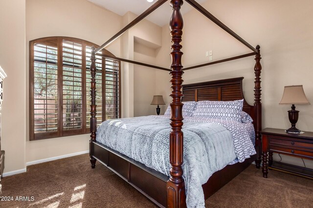 bedroom featuring dark carpet and a towering ceiling