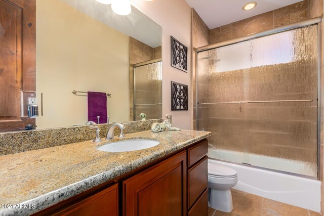 full bathroom with vanity, ceiling fan, bath / shower combo with glass door, toilet, and tile patterned floors