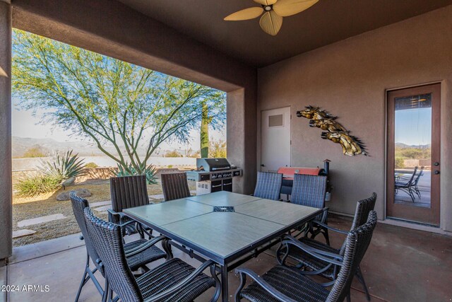 view of patio with ceiling fan, a mountain view, and area for grilling