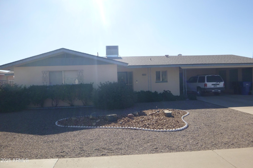 ranch-style home with cooling unit and a carport