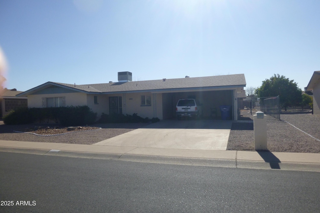 ranch-style house featuring a garage and cooling unit