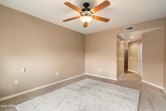 spare room featuring ceiling fan, baseboards, visible vents, and light carpet