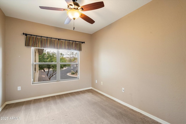 carpeted empty room with ceiling fan and baseboards