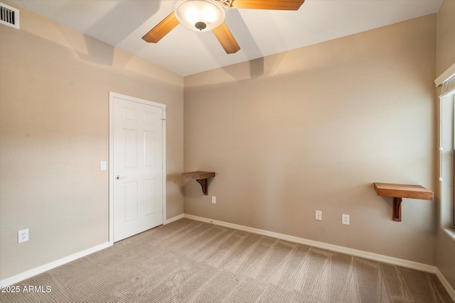 spare room with baseboards, light carpet, visible vents, and ceiling fan