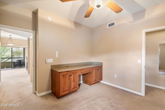 unfurnished office featuring ceiling fan, baseboards, visible vents, and light carpet