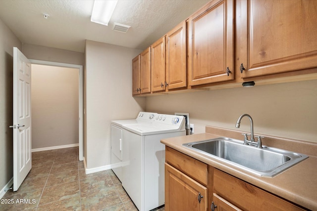 laundry room featuring baseboards, visible vents, cabinet space, a sink, and washer and clothes dryer