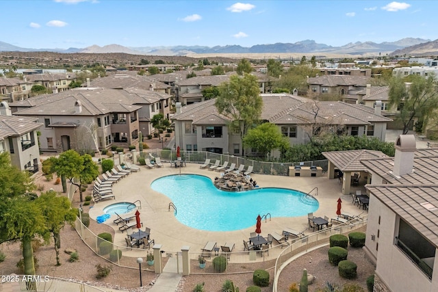 pool with a mountain view, a residential view, a patio, and fence