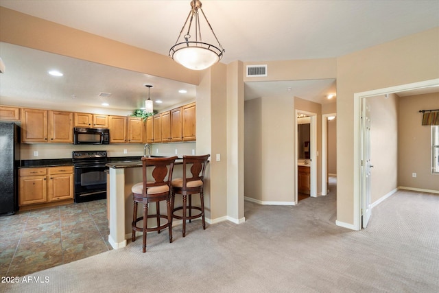 kitchen featuring visible vents, baseboards, black appliances, dark countertops, and light colored carpet