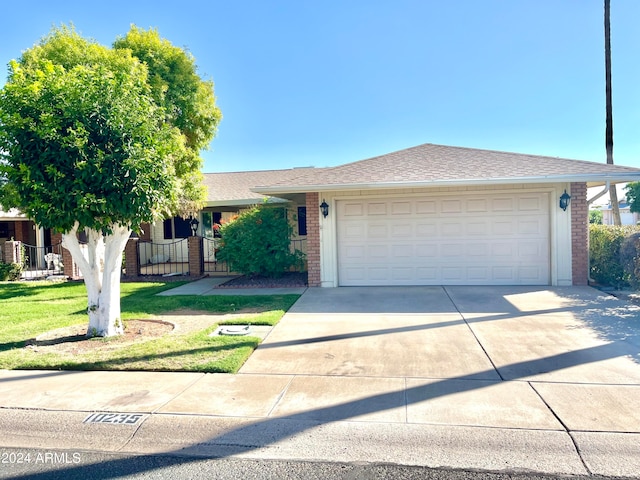 single story home featuring a front yard and a garage