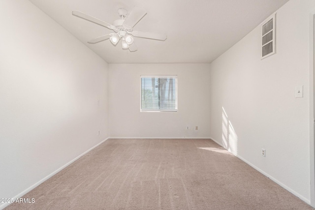 empty room with baseboards, a ceiling fan, visible vents, and light colored carpet