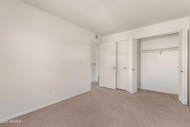 unfurnished bedroom featuring light carpet, visible vents, and baseboards