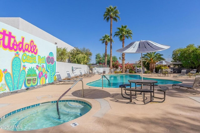 community pool featuring a community hot tub, a patio area, fence, and a water play area