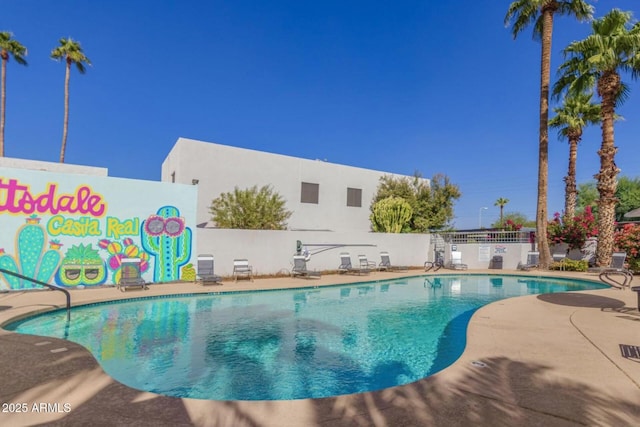 pool with a patio area and fence