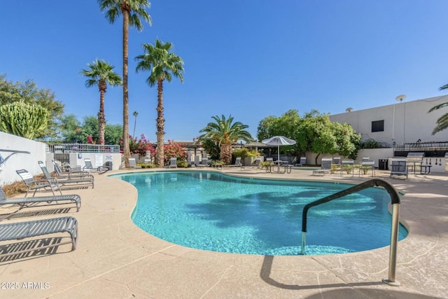 pool with fence and a patio