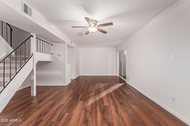 unfurnished living room featuring visible vents, dark wood finished floors, stairway, and ceiling fan