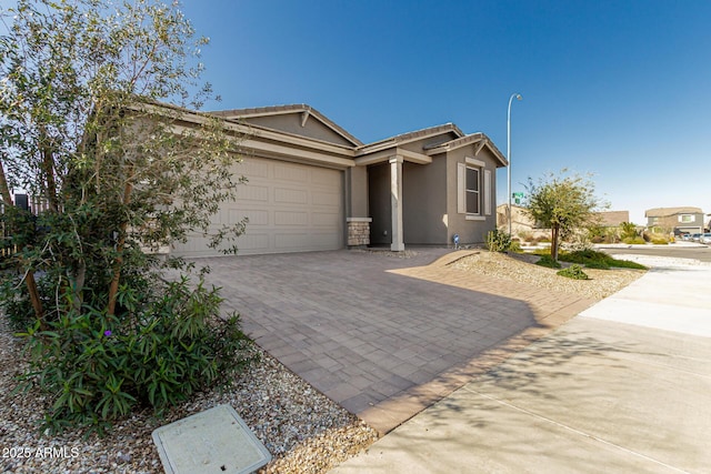 ranch-style house with decorative driveway, a garage, and stucco siding