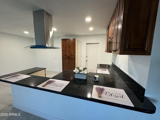 kitchen featuring island exhaust hood, dark brown cabinetry, a peninsula, and recessed lighting