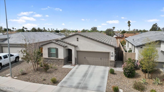 view of front of house featuring stucco siding, stone siding, concrete driveway, an attached garage, and a tiled roof