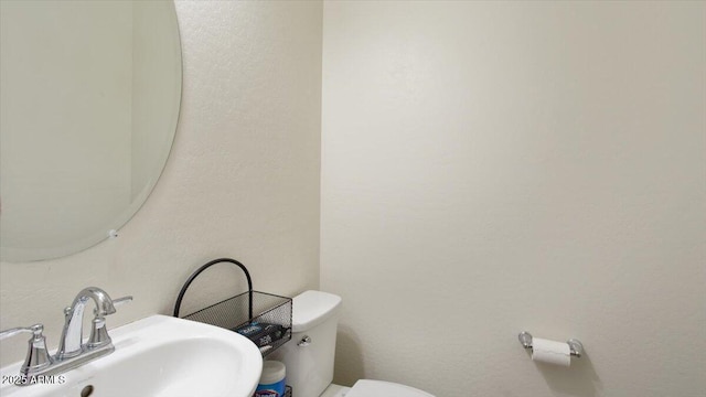 half bathroom featuring a sink and toilet