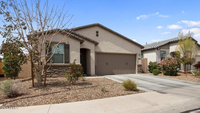 view of front of house with a tile roof, concrete driveway, a garage, and stucco siding