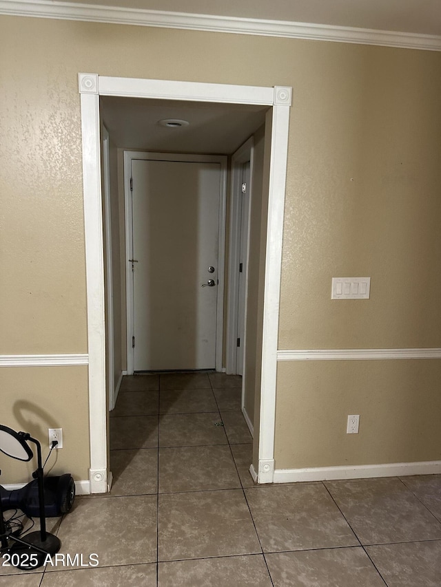 hallway with tile patterned flooring and crown molding