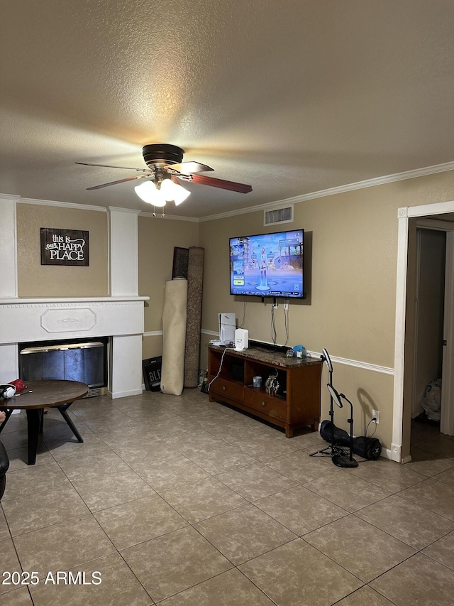 tiled living room featuring crown molding, ceiling fan, and a textured ceiling