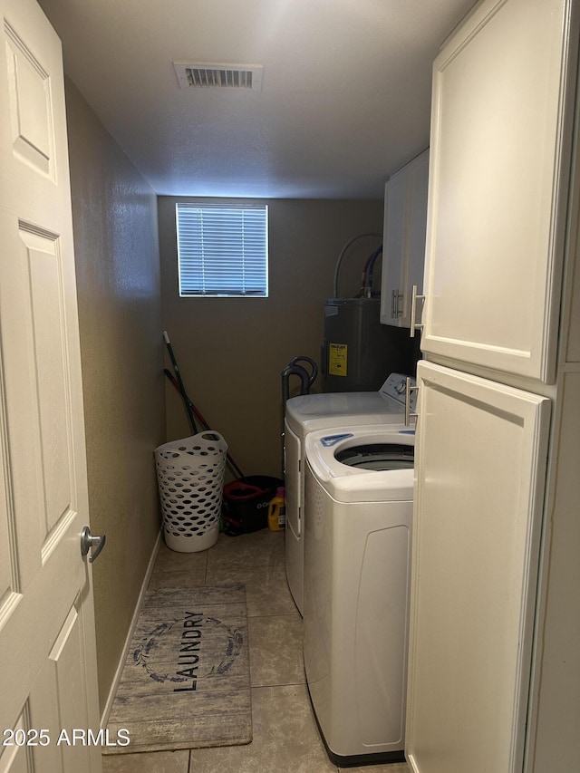 laundry room featuring cabinets, independent washer and dryer, light tile patterned floors, and water heater