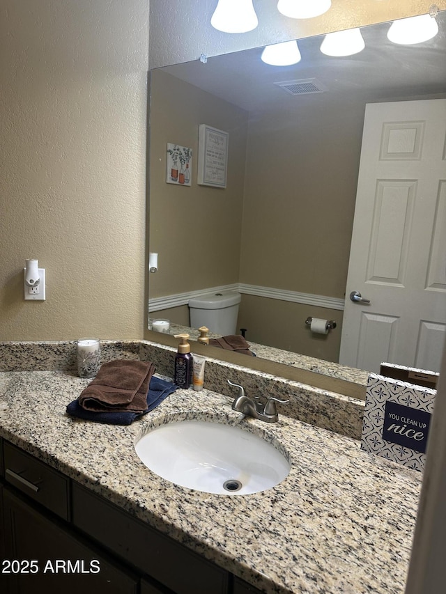 bathroom featuring vanity and toilet