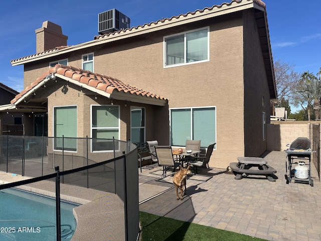 back of house featuring a pool, a patio, and central AC