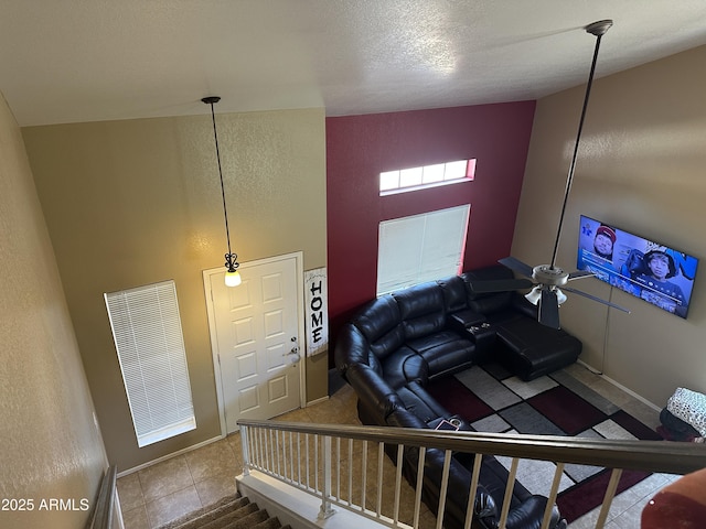 living room featuring light tile patterned floors, a textured ceiling, and high vaulted ceiling