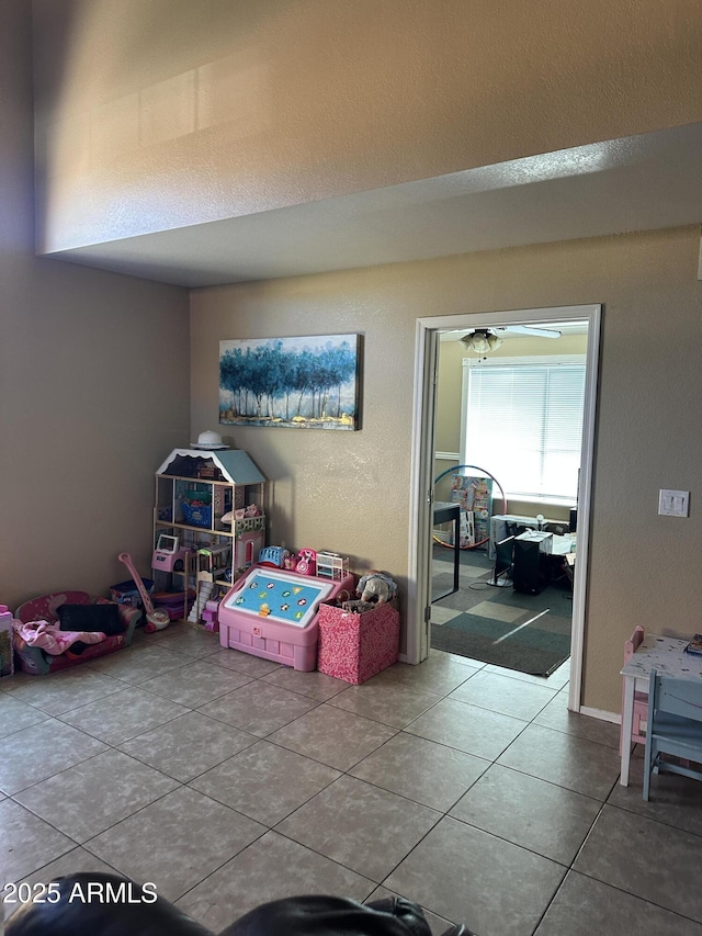 game room with ceiling fan and tile patterned flooring