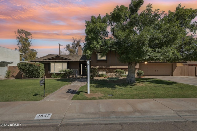2847 S Bala Dr, Tempe, AZ 85282 - view of front of house featuring concrete driveway, a lawn, stone siding, a chimney, and an attached garage
