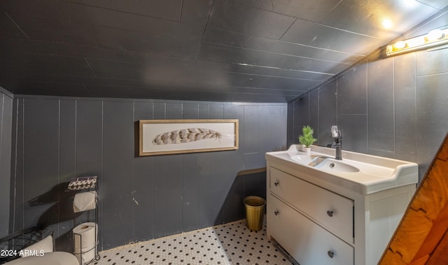 bathroom with lofted ceiling, vanity, toilet, and tile patterned floors