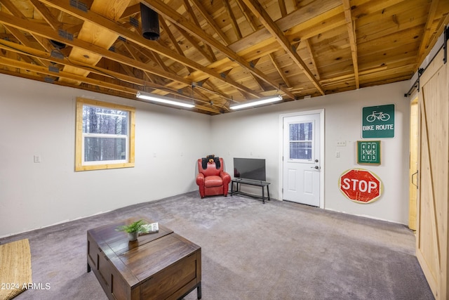 sitting room featuring a barn door and carpet flooring